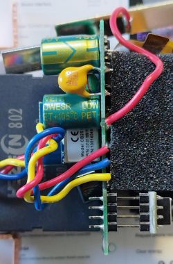 Close-up of the inside of an electronic device with colorful wires and capacitors visible.