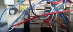 Widok na wnętrze urządzenia elektronicznego z wieloma kablami i komponentami.