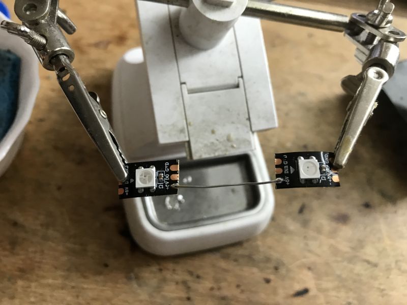 Soldering WS2812B LEDs on a Workbench Two WS2812B LED diodes being soldered by robot arms on a workbench.