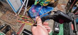 Przewody elektryczne w ręku, widoczny brązowy i biały kabel.