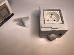 ATLO-S1IP5-TUYA outdoor electrical socket with mounting screws in a plastic bag.