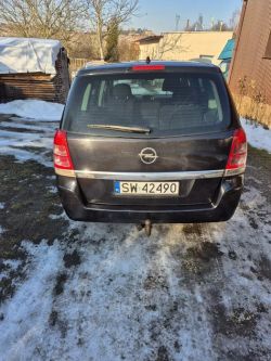 Rear of a black Opel with license plate SW 42490 parked on an icy driveway.