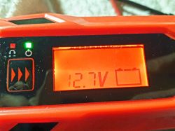Wyświetlacz prostownika pokazujący napięcie 12,7V i zapaloną zieloną diodę