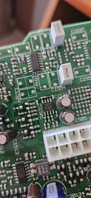 Zbliżenie na płytkę drukowaną subwoofera z widocznymi układami scalonymi i kondensatorami.