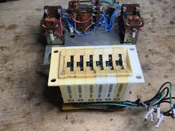 Inside of a device with three relays and a lever-based setting module on a workshop table