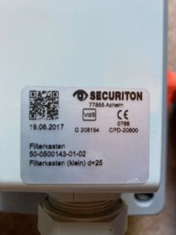 Naklejka informacyjna na urządzeniu Securiton z datą produkcji.