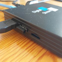 Digital tuner on a table with various connected cables.