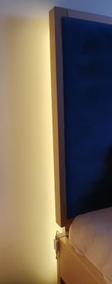Vertically mounted LED strip behind the bed in the bedroom.