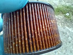 Brązowy, zużyty filtr paliwa do Citroena Berlingo z widocznymi osadami.