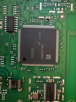 The image shows a close-up of a printed circuit board with visible integrated circuits and electronic components.
