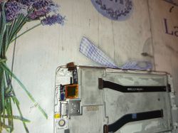 Wnętrze rozebranego telefonu Xiaomi z widocznymi taśmami i komponentami