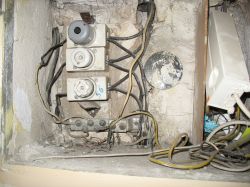 Stary panel elektryczny z przewodami i ceramicznymi bezpiecznikami.