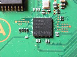 Zbliżenie na płytę główną konsoli PS4, ukazujące układ scalony oraz pobliskie brakujące elementy.