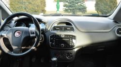 Wnętrze Fiata Grande Punto 1.4 z 2013 roku, widok na deskę rozdzielczą i radio
