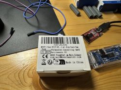 Box and Electronic Components on a Desk Box with text and electronic components on a desk.