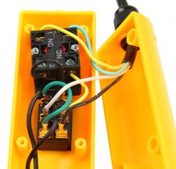 Otwarte żółte pudełko z przewodami i złączami elektrycznymi.