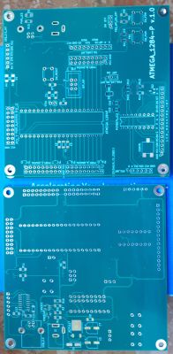 Dwie niebieskie płytki PCB z wyraźnymi oznaczeniami i otworami montażowymi.