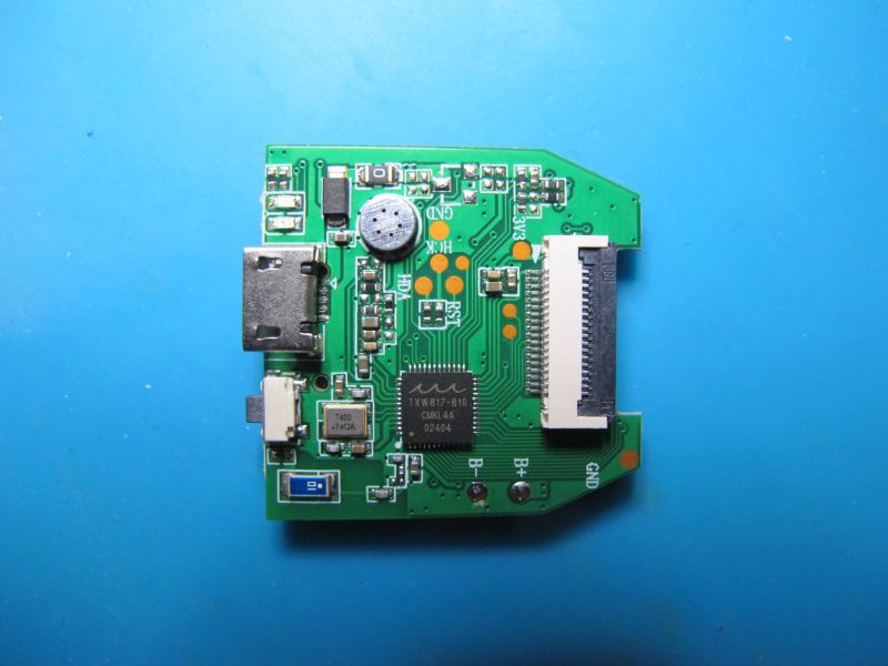 Green PCB with USB ports and a large ribbon connector on a blue background