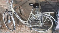 Rower elektryczny Gazelle w garażu z kamienną podłogą i drewnianą ścianą w tle