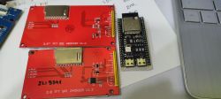 Dwa czerwone wyświetlacze TFT SPI i moduł ESP32 umieszczone obok laptopa.