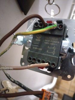 Zdjęcie instalacji elektrycznej z widocznymi przewodami podłączonymi do włącznika.
