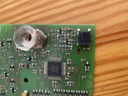 Zbliżenie na płytkę PCB z elementami SMD i zwojem sprężynowym
