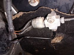 Element układu hamulcowego z przewodami zamontowanymi w pobliżu prawego przedniego koła Volkswagen Lupo 3L 2001.