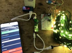 WiFi Control for WS2812 LED Set WS2812 LED set connected to a controller with a display, next to a smartphone with a control app.