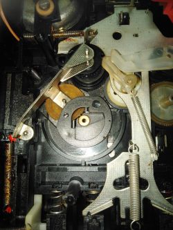 Wnętrze magnetofonu Unitra Finezja 1 z widocznymi częściami mechanicznymi i zębatkami.