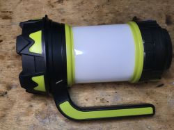 Lampka kempingowa-powerbank z rączką i zielonymi akcentami.
