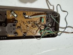 Widok wnętrza domofonu z widoczną płytką drukowaną i przewodami