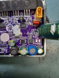 Płytka drukowana z elementami elektronicznymi, w tym kondensatorami i złączem.