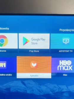Ekran telewizora z kilkoma ikonami aplikacji, w tym Google Play Store, Aptoide i HBO Max.