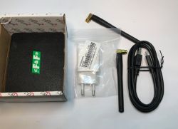 Zestaw akcesoriów elektronicznych: anteny, ładowarka USB, przewód zasilający oraz pudełko z pianką.