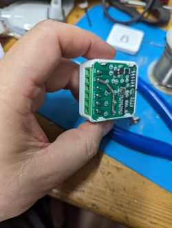A person holding an electronic switch in hand with visible integrated circuit and soldered components.