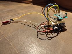 Simplified electronic device with colorful wires on a wooden base.