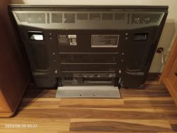 Tylny panel telewizora Pioneer stojącego na podłodze przy ścianie.
