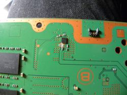 Zbliżenie na zieloną płytę drukowaną z widocznymi elementami elektronicznymi i ścieżkami.