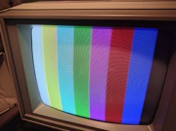 Ekran monitora CRT z pionowymi pasami kolorów; widoczne fale i przebarwienia na zielonym i czerwonym.