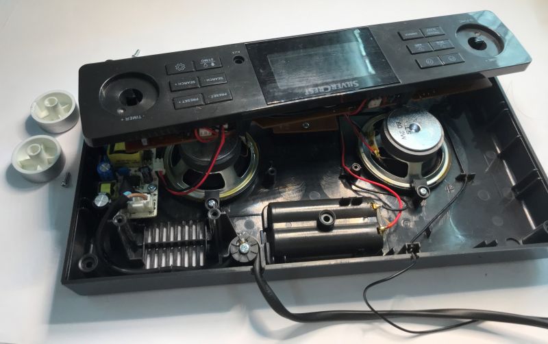 Disassembled SilverCrest radio showing speakers, battery holder, and circuit board