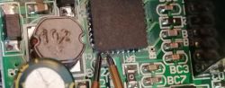 Close-up of a microcontroller on a PCB with connected probe wires.