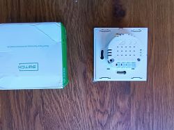 Back View of a Switch with Packaging Two-part image showing packaging and the back of a switch on a wooden surface.