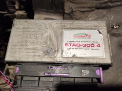 Sterownik gazu STAG-300-4 zamontowany w komorze silnika, z widocznymi oznaczeniami producenta i wersji modelu.