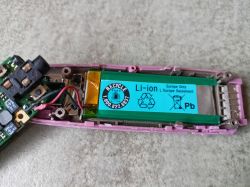 Zbliżenie na wnętrze urządzenia z widoczną baterią Li-ion.