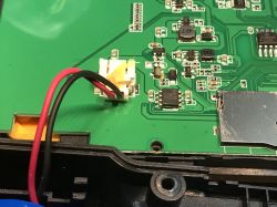 Widok wnętrza modułu LCD z układami elektronicznymi na zielonej płytce obwodu drukowanego.
