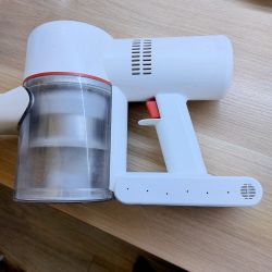 Dreame V9 Vacuum Cleaner on Wooden Surface Cordless handheld vacuum cleaner Dreame V9 lying on a wooden surface.