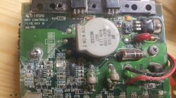 Zbliżenie na płytkę drukowaną z widocznymi elementami elektronicznymi i oznaczeniami.