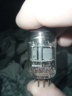 Lampa elektronowa trzymana w palcach, widoczne elementy wewnętrzne i piny