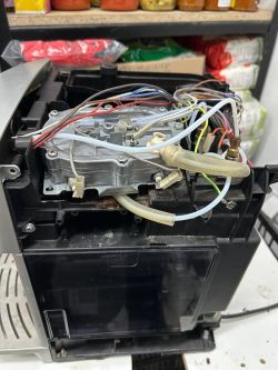 Wnętrze ekspresu do kawy z widocznymi przewodami i elektrozaworem
