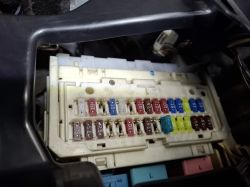 Skrzynka bezpieczników wewnątrz Toyoty Yaris II 1.3 benzyna 2010 Zbliżenie na skrzynkę bezpieczników w Toyocie Yaris z widocznymi bezpiecznikami różnej wartości